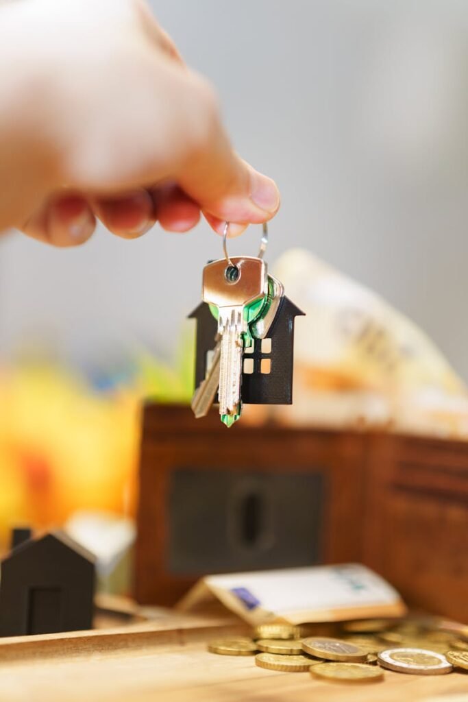 Garrasino Inmobiliaria Barcelona - Hand holding house keys representing real estate investment with coins and wallet.